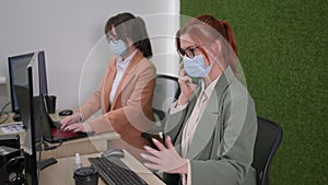 observance of precautionary measure, female colleagues in glasses and medical mask to protect against virus and