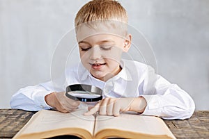 Observant inventive boy using a lens for reading