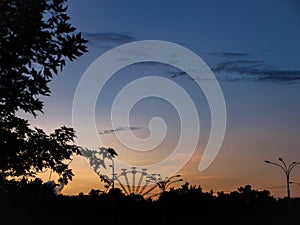 Observation wheel in the distance with sunset background in Kyiv