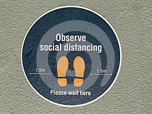 Observe social distancing sign on city street photo