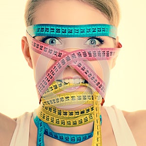Obsessed girl by your body. Woman with measure tapes.