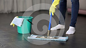 Obsessive with cleanliness young lady thoroughly washing floor of her house