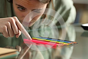 Obsessive compulsive woman aligning up pencils on a table photo