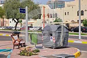 Obsolete arabic style home furniture thrown near garbage container on city street.Getting rid of old junk.Urban ecology.