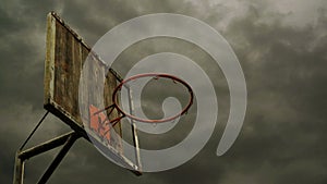 Obsolete Basketball hoop with cage with clouds time lapse footage in background.