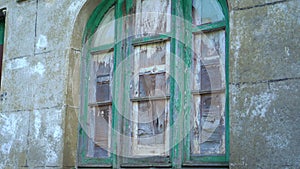 Obsolete derelict boarded up weathered wooden window of ruined old house