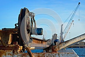 Obsolete equipment on a background of modern cranes