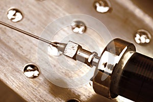 Obsolete glass syringe on the steel surface, textured medical background