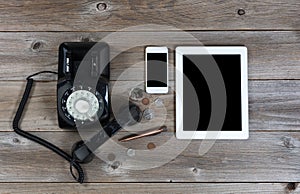 Obsolete and modern communication devices on rustic wooden board