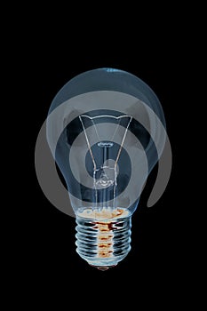 Obsolete uneconomical and unecological incandescent bulb with tungsten filament photo