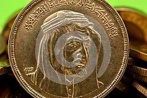 Obverse side of an Egyptian one pound coin, 1 LE coin year 1976, 1396 AH with Bust of King Faisal half right, Translation (