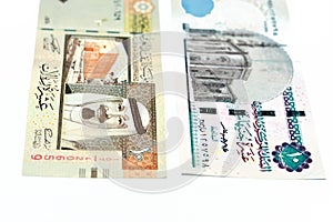 Obverse sides of an old Saudi Arabia 10 ten riyals banknote with 10 LE ten Egyptian pounds bill isolated on a white background,