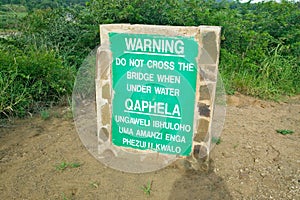 Obvious sign warns not to cross bridge when under water in Umfolozi Game Reserve, South Africa, established in 1897 photo