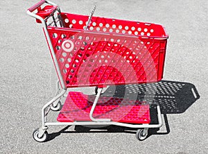 Ocala, Florida 2-27-2024 abandoned empty Red shopping basket, cart, stroller, buggy, trolley isolated on concrete parking lot at a