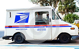 Ocala, Florida, USA November 2, 2023 USPS truck delivering mail on suburban street parked in occupied space. red white and blue