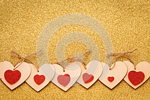 Occasional decorative hearts on a shiny gold background with a place for an inscription