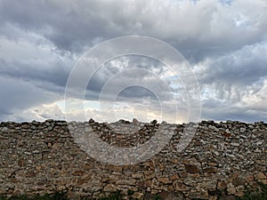 occitanie view of tormented clouds above a stone wall