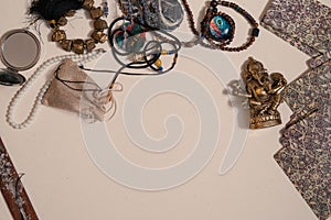 Occult symbols laid out on a white background. Aroma stick, Ganesha figurine, stone rosary