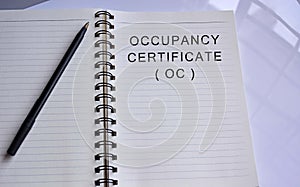 Occupancy certificate text written on a notepad with a pen photo
