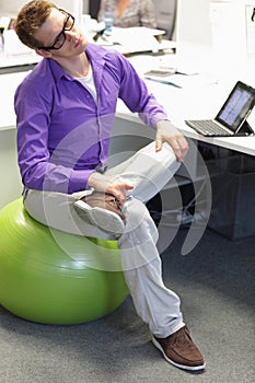 Occupational disease prevention - man on stability ball having break for exercise