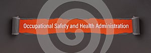 Occupational Safety and Health Administration - appearing behind torn paper