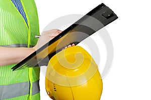 Occupational Safety and Health, inspector in a protective vest with a construction helmet writes with a pen on a clipboard,