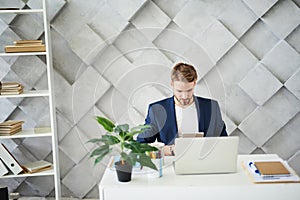 Busy male sitting at desktop with tablet