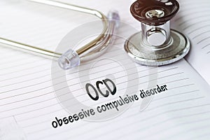 OCD - Obsessive Compulsive Disorder text on a medical card next to a pen stethoscope