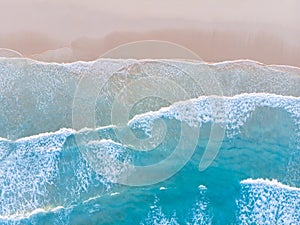 Ocean beach aerial top down view with blue water, waves with foam and spray and fine sand, beautiful summer vacation holidays photo