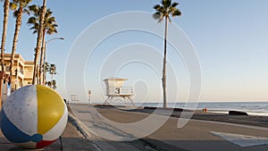 Ocean beach California USA. Ball, lifeguard tower, life guard watchtower hut, beachfront palm tree.
