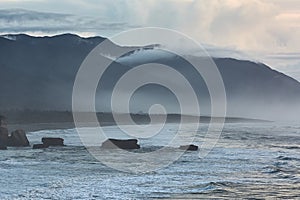 Ocean beach cliffs and mist in New Zealand