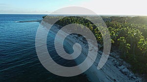 Ocean beach with coconut palms and sunrise sunshine. Aerial view of tropical coastline on Fuvahmulah island