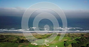 Ocean beach waves clashing on shore and Golf course