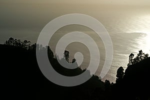 Ocean behind a cliff in the backlighting