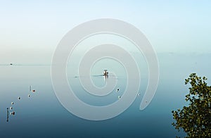 The ocean blend into the sky - a fishing boat heads out to sea on a dreamy calm overcast day when water and sky are the same paste