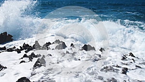 Ocean blue water Waves breaking over dangerous rocks, Sea storm concept
