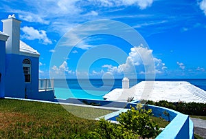 Ocean Blue Waters with black Rocky Beach Blue Sky white clouds in the horizon