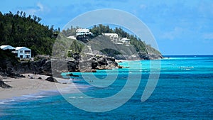 Ocean Blue Waters with black Rocky Beach Blue Sky white clouds in the horizon