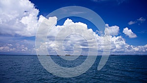 The ocean with bright blue skies and white clouds.