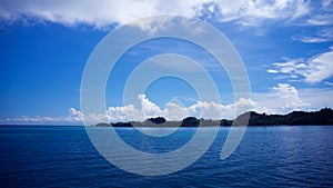 The ocean with bright blue skies and white clouds.