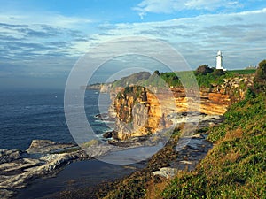 Ocean Cliffs With a White Lighthouse