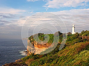 Ocean Cliffs With a White Lighthouse