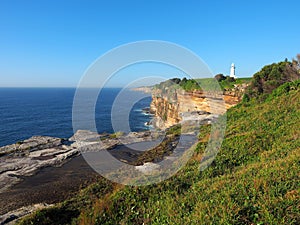 Ocean Cliffs With a White Lighthouse