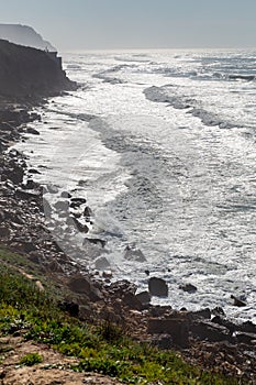 Ocean coast with grass, moviment waves with foam. photo