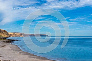 Ocean coastline with sandy beach and picturesque hills