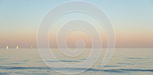 Ocean during evening with three yachts