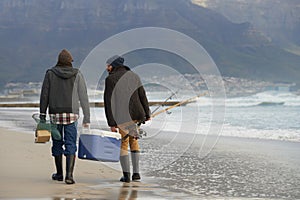 Ocean, fishing and men walking together with cooler, tackle box and holiday conversation from back. Beach, fisherman and