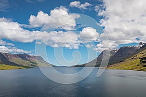 Ocean fjord of Seydisfjordur, Iceland, on a warm, partly cloudy day