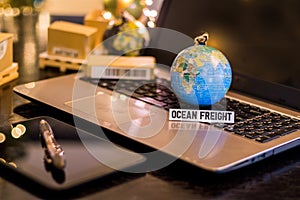 Ocean Freight - still life logistics business concept with laptop, phone, mini shipping cartons