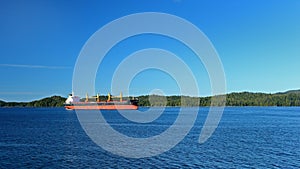 Ocean freighter on blue water with an island for background